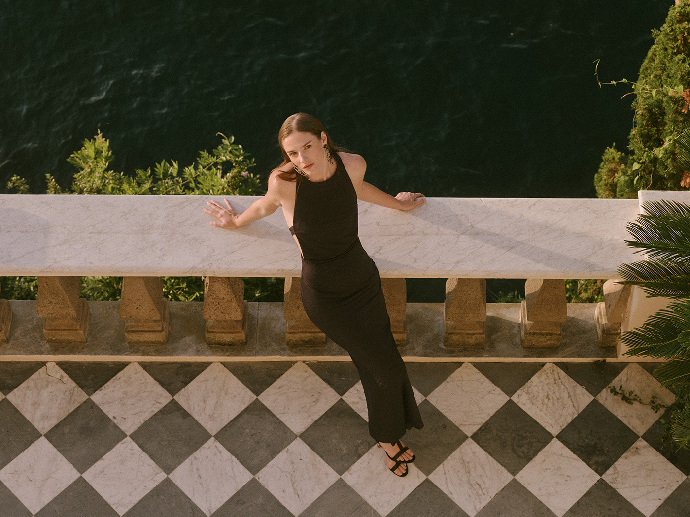 Woman in black dress overlooking sea